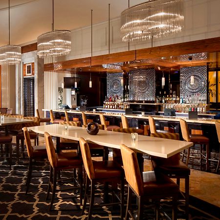Trump International Hotel Лас Вегас Екстериор снимка The photo shows a sophisticated and modern bar or lounge area. There’s a long, elegant countertop with high-backed chairs positioned along it. Above the bar, there are stylish, circular chandeliers that provide soft lighting. The bar itself is well-s