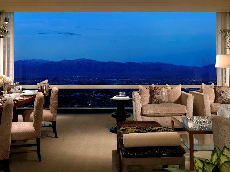 Trump International Hotel Лас Вегас Екстериор снимка The image shows a luxurious interior space, likely a dining or lounge area, with elegant furnishings. There are plush chairs and sofas arranged around a coffee table, creating a comfortable setting. A formal dining table is also present, suggesting a