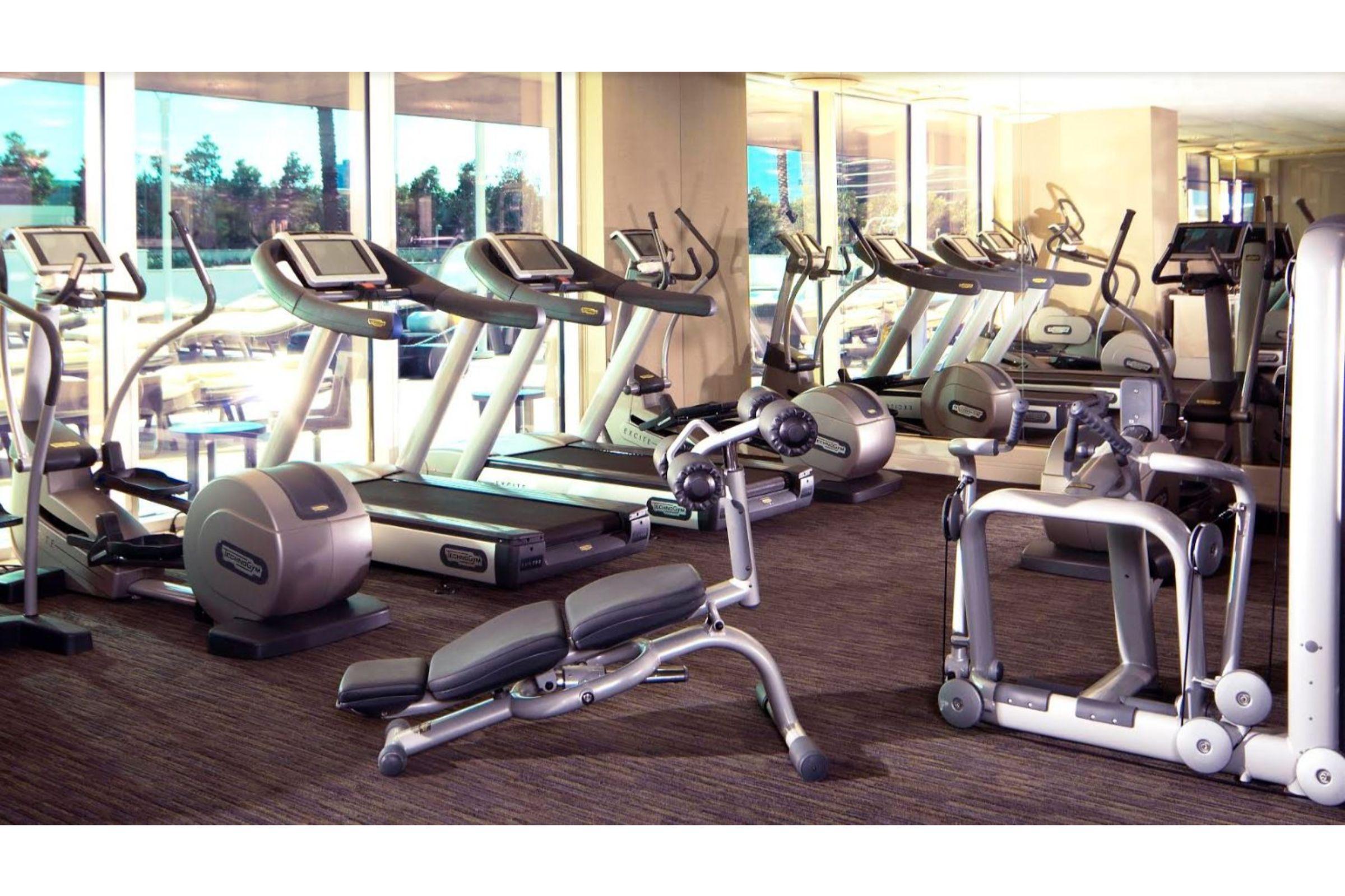 Trump International Hotel Лас Вегас Екстериор снимка The photo shows a modern gym or fitness center. It features several exercise machines, including treadmills and elliptical trainers, arranged in a spacious area with large windows that allow natural light to enter. There are also weights benches and 