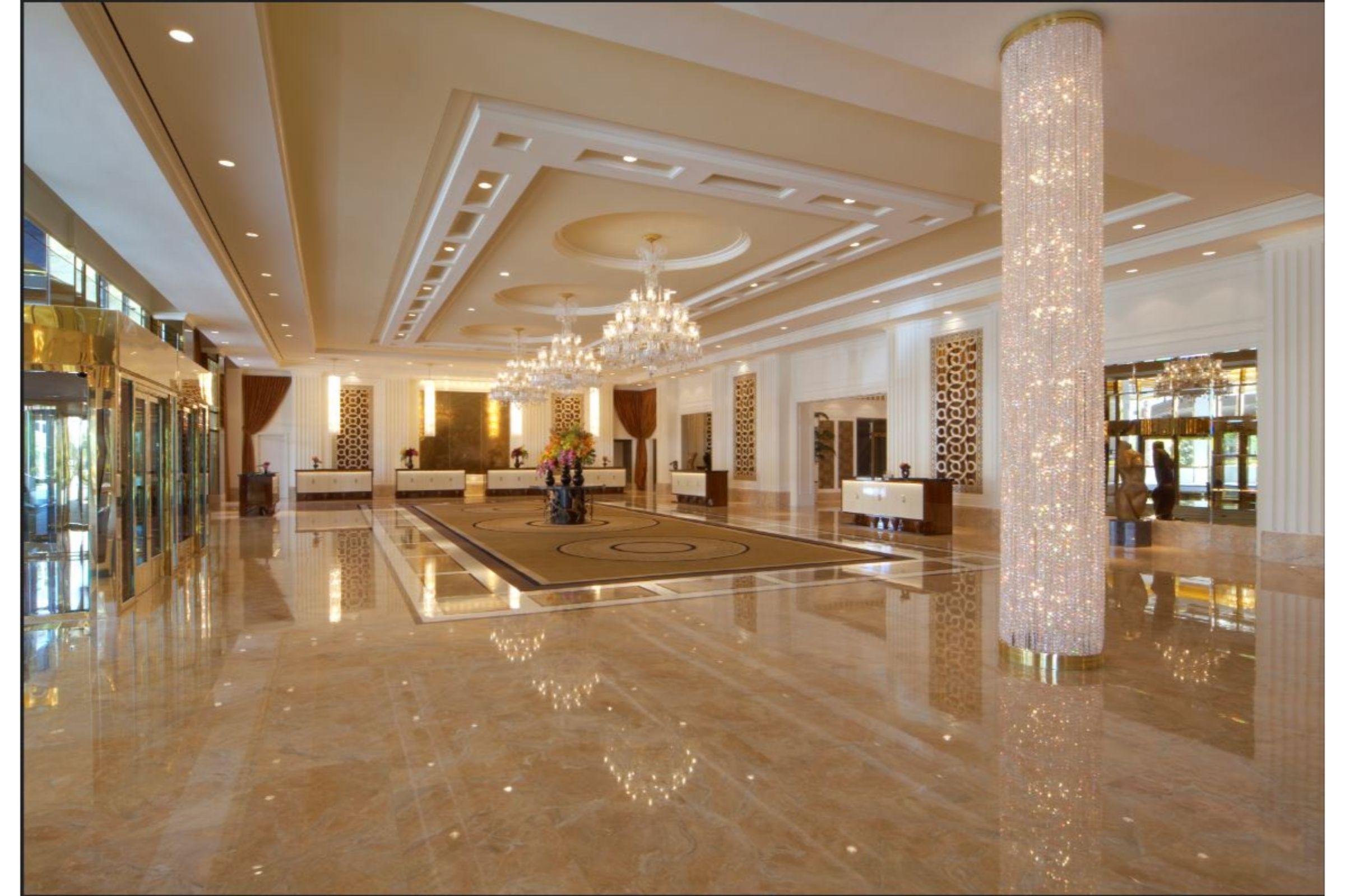 Trump International Hotel Лас Вегас Интериор снимка The photo depicts a spacious and elegantly designed hotel lobby. The space features a polished marble floor that reflects light, enhancing the room's brightness. High ceilings and detailed moldings create an upscale atmosphere. Chandeliers hang from 