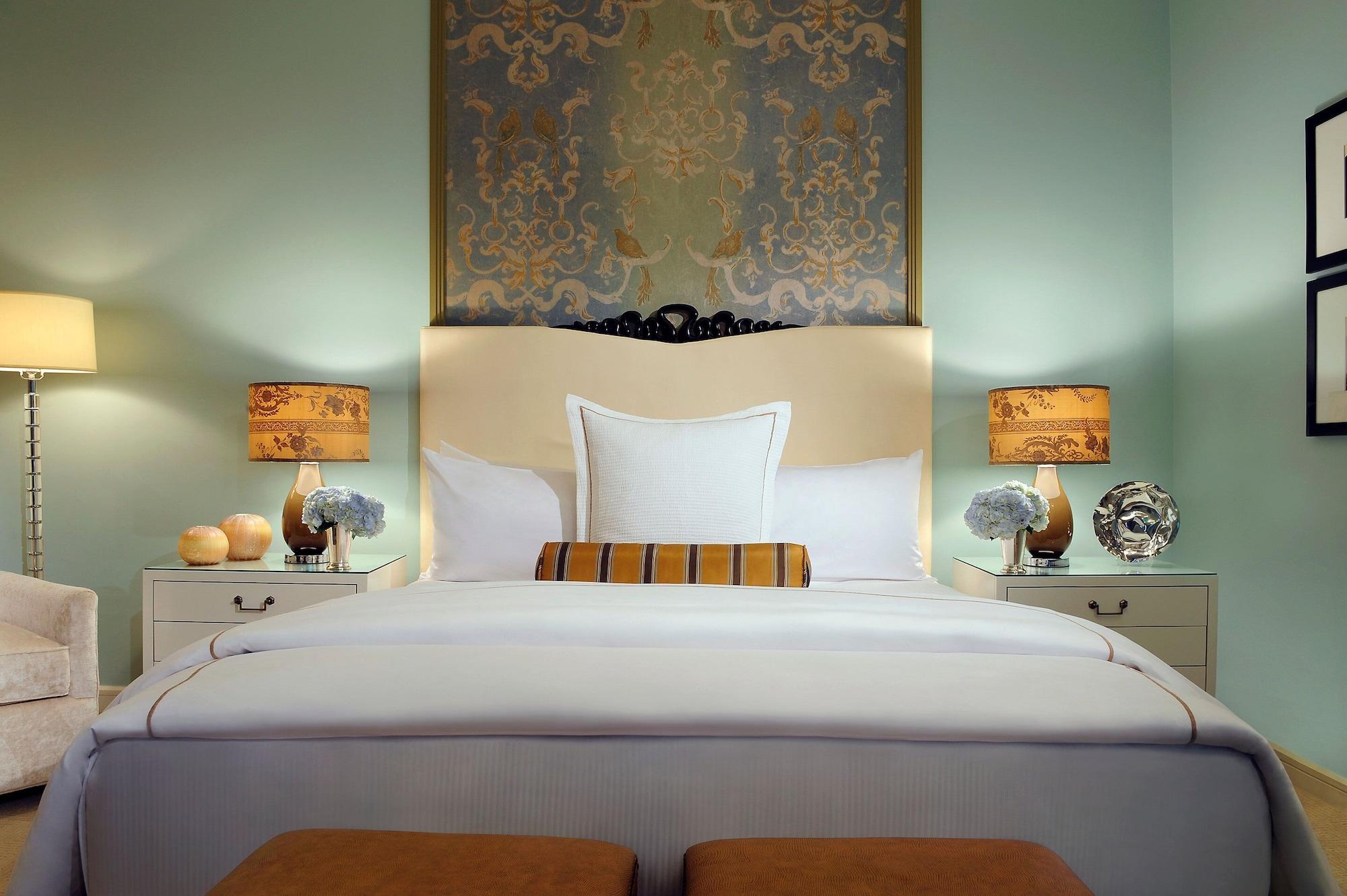 Trump International Hotel Лас Вегас Екстериор снимка The photo depicts a well-decorated bedroom. The focal point is a large bed with a padded headboard, adorned with multiple pillows and a decorative pillow in the center. On either side of the bed are decorative lamps with patterned shades, providing s