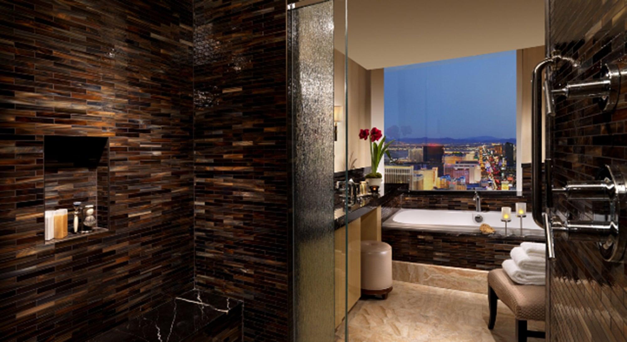 Trump International Hotel Лас Вегас Екстериор снимка The photo shows a luxurious bathroom with a modern design. On one side, there is a spacious walk-in shower with a textured glass wall. The walls are adorned with dark, elegant tiles that give a sophisticated feel. Opposite the shower, there is a larg