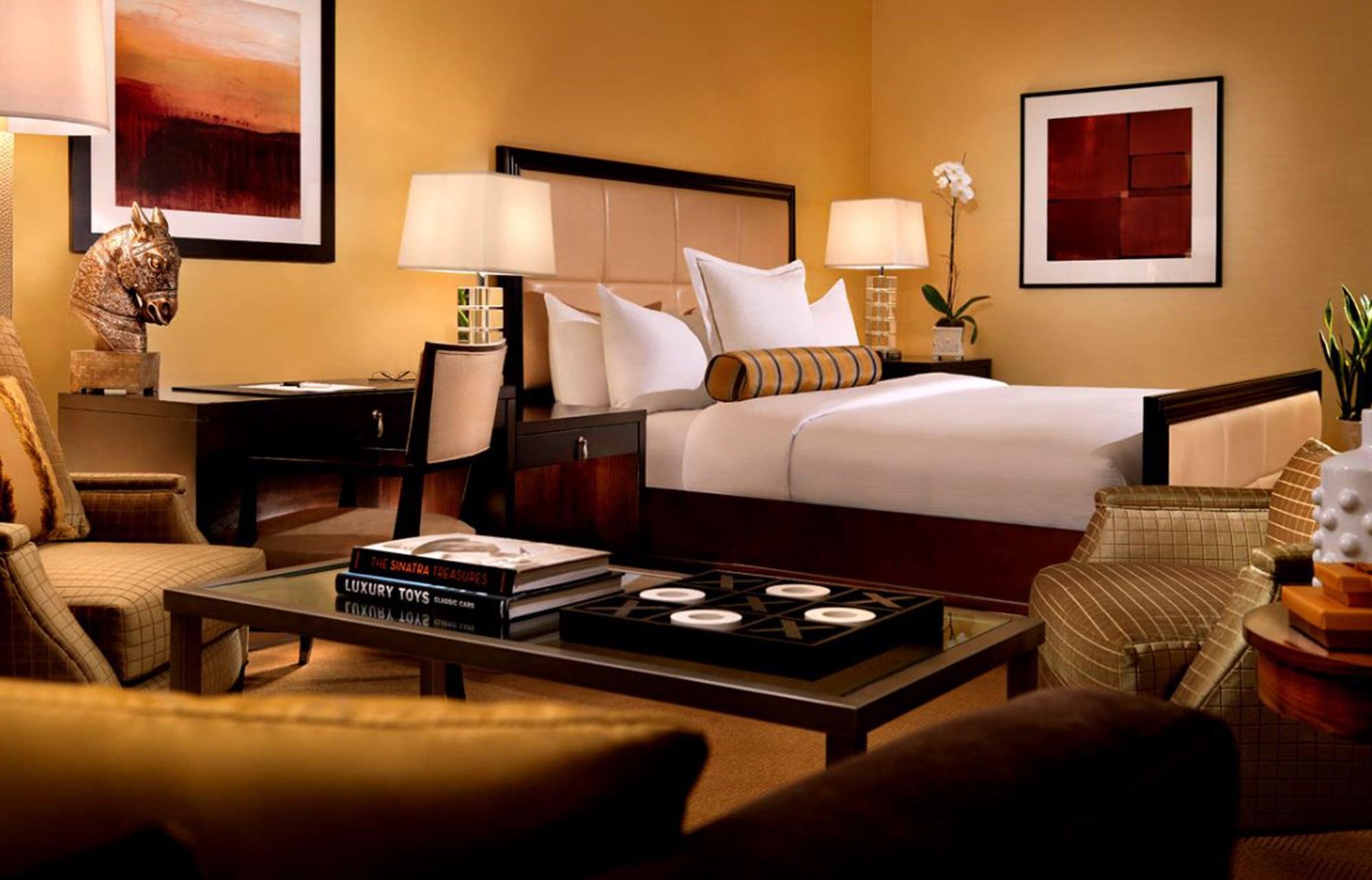 Trump International Hotel Лас Вегас Екстериор снимка The photo shows a cozy hotel room designed for comfort and relaxation. It features a large bed with white linens and decorative pillows, placed against a neutral-colored wall. There are bedside tables with lamps on either side of the bed. 

In additi