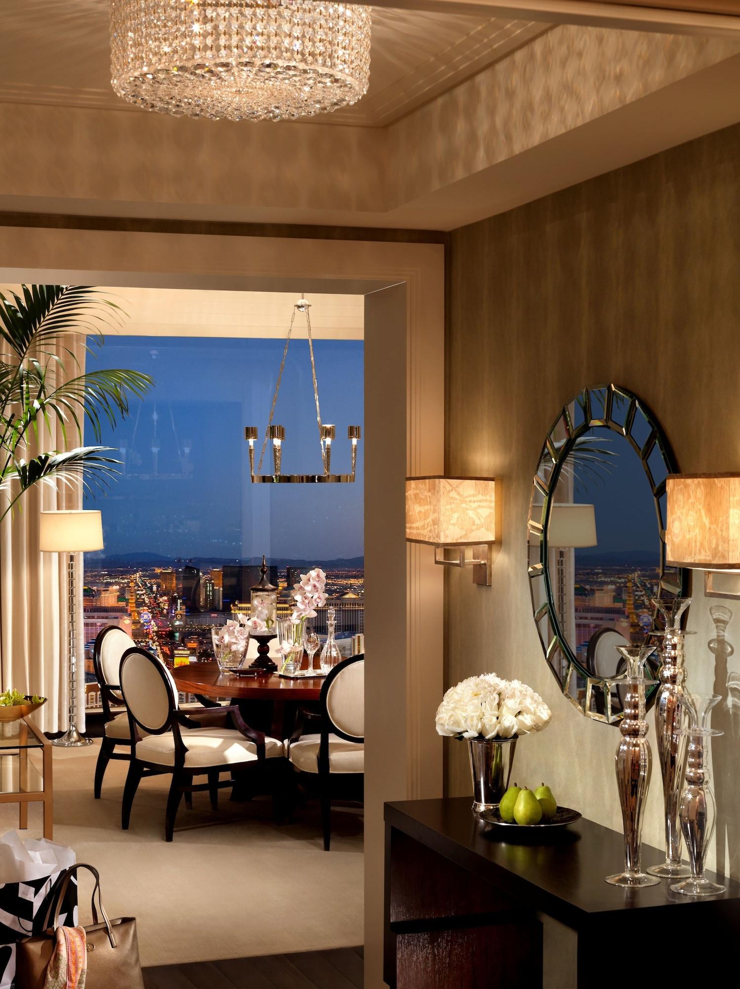 Trump International Hotel Лас Вегас Екстериор снимка The photo shows a stylish and elegantly designed interior space, possibly a dining area or living room. It features a round wooden dining table set with glasses and decor, surrounded by black and white upholstered chairs. Large windows offer a view o