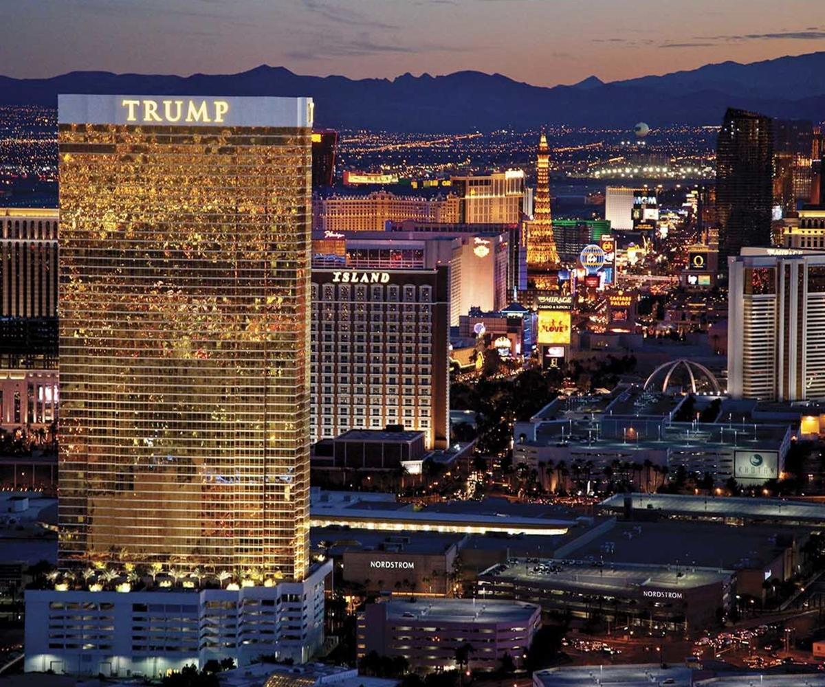 Trump International Hotel Лас Вегас Екстериор снимка The photo depicts a nighttime view of Las Vegas, showcasing the illuminated skyline. Prominently featured in the foreground is a tall building with the name "TRUMP" displayed at the top. Surrounding this building are various other hotels and attracti