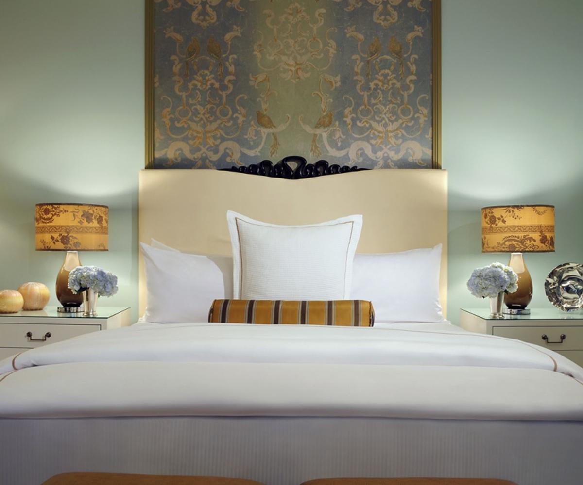 Trump International Hotel Лас Вегас Екстериор снимка The photo shows a stylish bedroom featuring a large bed with a light-colored headboard. The bed is adorned with fluffy white pillows and a decorative striped pillow in the center. On either side of the bed are nightstands, each topped with a lamp fea