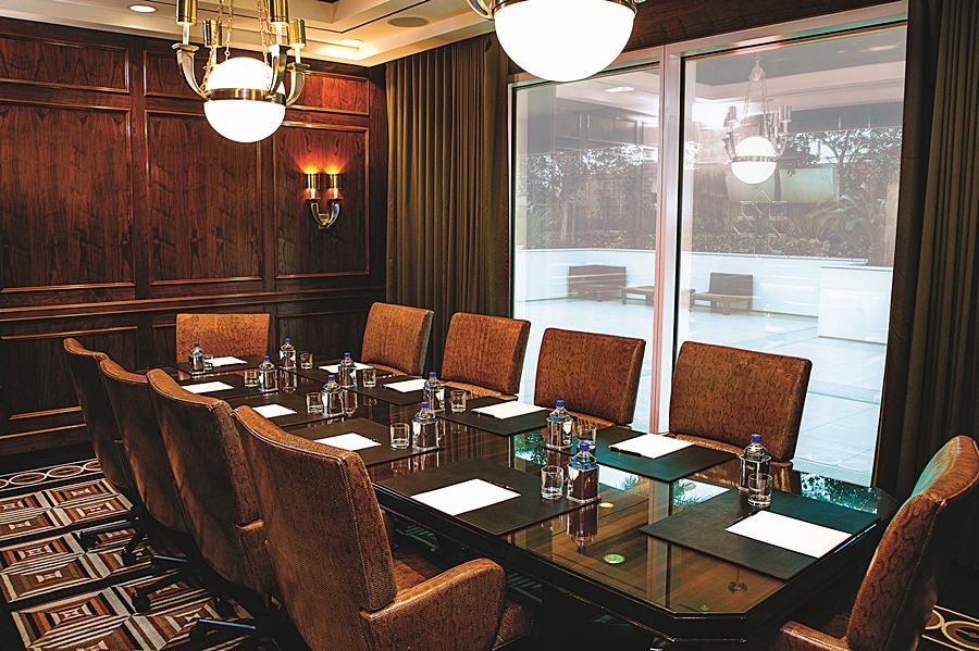 Trump International Hotel Лас Вегас Екстериор снимка The photo depicts a conference room featuring a long, rectangular table surrounded by several chairs. The table has a glass top and is set up for a meeting, with notepads and water bottles placed in front of each chair. The room has wooden paneling o